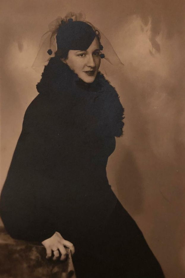 Schwarz-weiß-Porträt von Mary Elizabeth Taylor in einem schwarzen Kleid und Schleier aus den 1920er Jahren, sitzend mit warmem Ausdruck und dezentem Make-up.