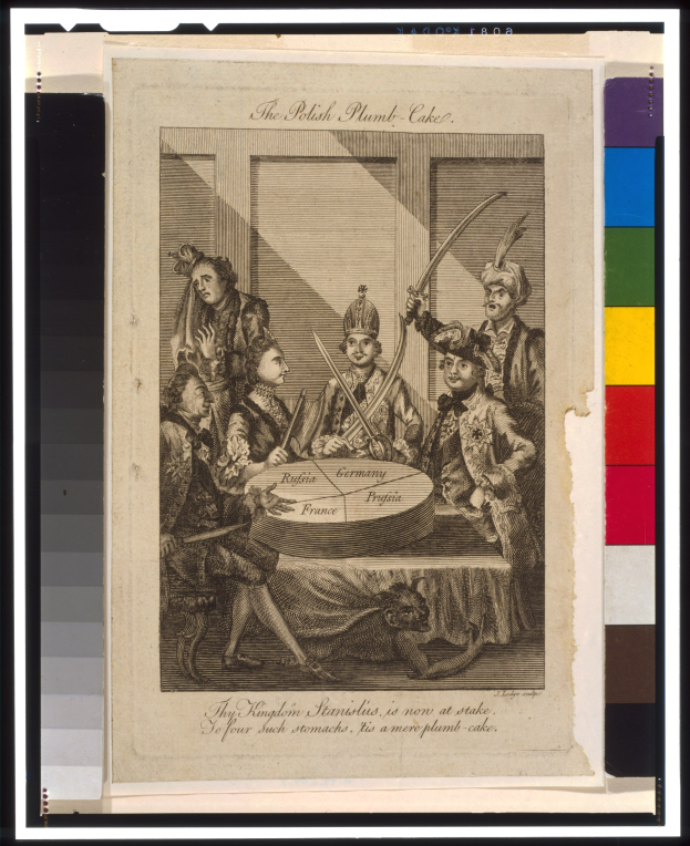 Gruppe von Menschen in traditioneller Kleidung, die um einen Tisch mit einem dekorierten Teller sitzen, vor einem schwarzen Hintergrund.