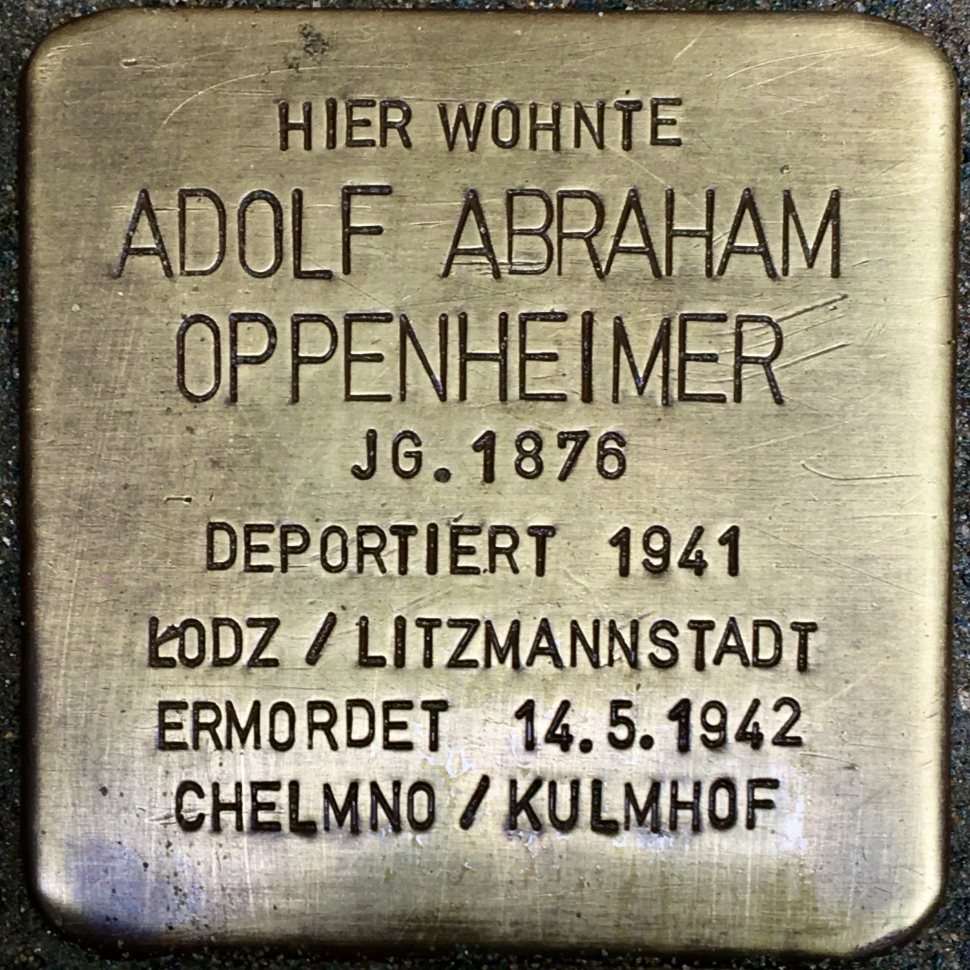 Metallplatte an einem Gebäude mit der eingravierten Inschrift "Adolf Abraham Oppenheimer".