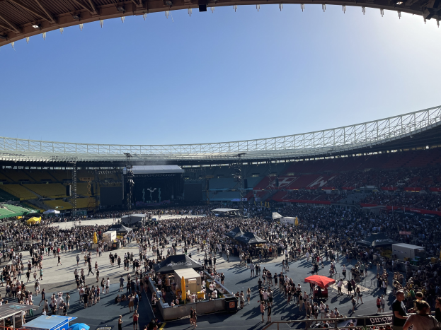 Eine große Menschenmenge versammelt sich vor einem Stadion mit Zelten, Absperrungen und einem beleuchteten Schuppen im Hintergrund während der Weltmeisterschaft 2014.