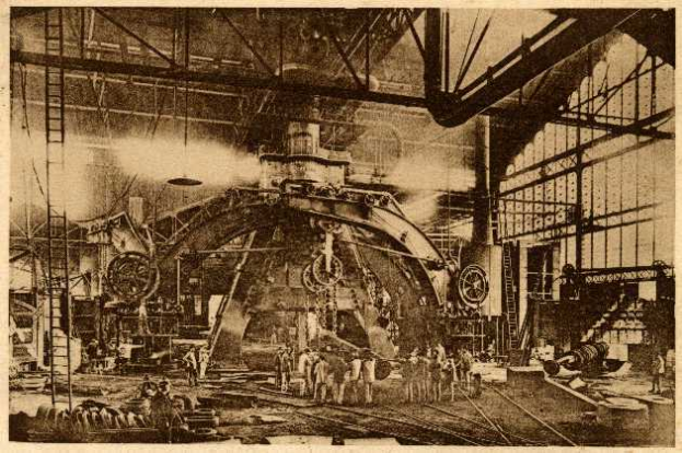 Ein Schwarz-Weiß-Foto einer Fabrikszene bei Cadillac Steel Works, das Arbeiter zeigt, die eine große Maschine bedienen, umgeben von Leitern und Stangen.