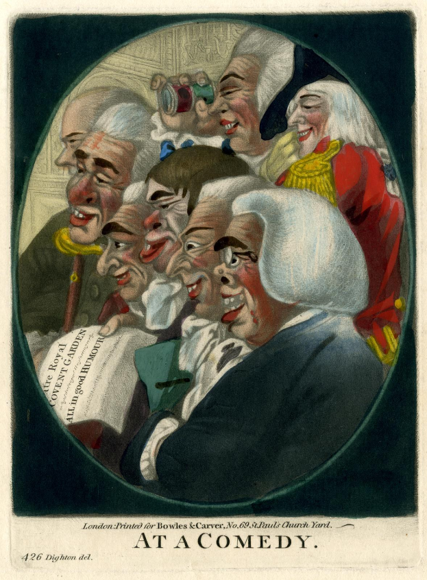 Gruppe von lachenden Menschen in einem Kreis bei einer Comedy-Veranstaltung, einer hält ein Blatt Papier.