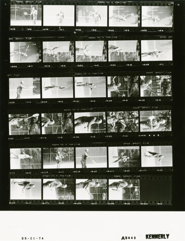 Schwarzes und weißes Foto eines konzentrierten männlichen Tennisspielers in einem weißen Hemd und Shorts, der einen Schläger hält, mit einem Filmstreifen-Hintergrund.