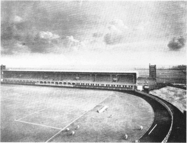 Schwarzes und weißes Foto eines Fußballfeldes mit einem Stadion, das von Bäumen umgeben ist und von einem bewölkten Himmel dominiert wird, mit dem Text "Stoke City Football Club" unten.