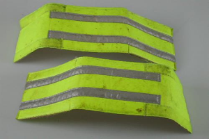 Zwei gelbe reflektierende Sicherheitswesten auf einer weißen Oberfläche ausgelegt.