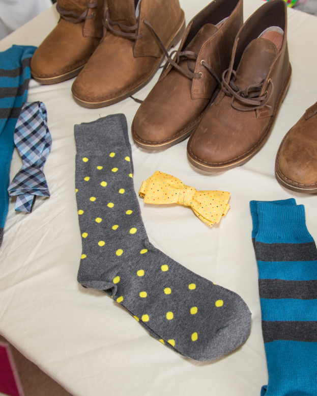 Eine Schleife, Socken und Schuhe werden auf einem weißen Tuch platziert.