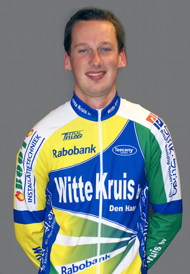 Ein Sportler bei einer Fotopose mit Namen von Sponsorenunternehmen auf seinem Hemd.
