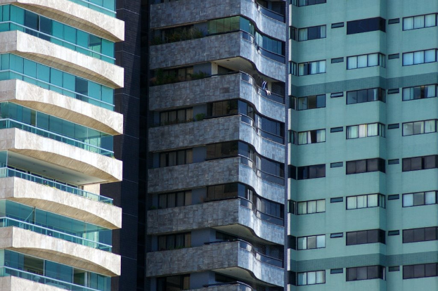 Verschiedene Gebäude unterschiedlicher Höhe und Gestaltung sind in einer städtischen Umgebung zu sehen.