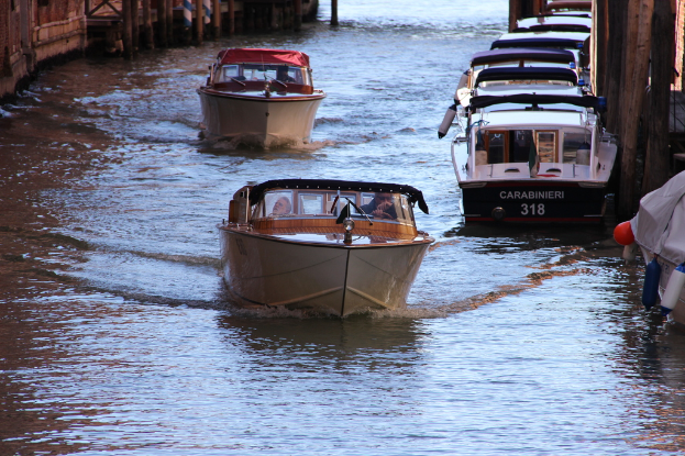 Mehrere Boote sind auf der rechten und in der Mitte eines Gewässers positioniert, mit Grenzen auf beiden Seiten des Bildes.