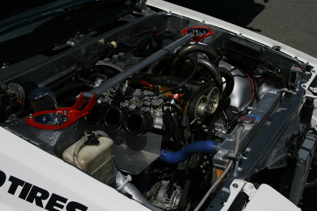 Ein Auto-Motor mit sichtbaren Röhren und einer Batterie.