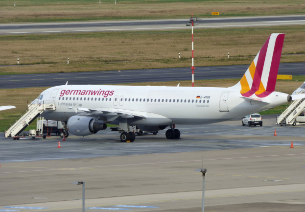 Germanwings Airbus A320-200 geparkt am Frankfurter Flughafen mit Bodenfahrzeugen, Verkehrsinseln, Pfählen und Gras im Hintergrund.