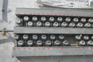 Ein Nahaufnahme eines Elektrizitätszählers, der an einer Gebäudewand montiert ist, mit einem Banner mit Text an der Spitze des Bildes.