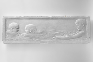 Drei Kinder beim Schwimmen in einem Pool, mit einer Wand im Hintergrund, dargestellt auf einem Schwarz-Weiß-Foto.