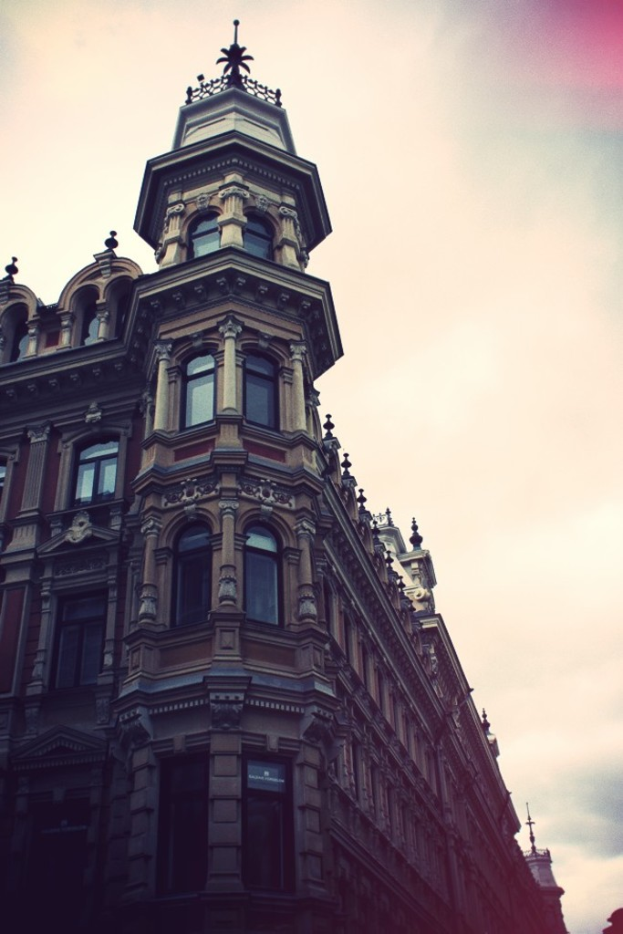 Ein Gebäude mit Glasfenstern unter einem bewölkten Himmel.