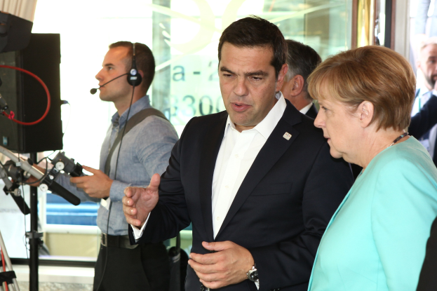 Zwei deutsche Führungspersonen, Angela Merkel und Joachim Gauck, stehen vor einer Glaswand mit einem Vorhang dahinter und sprechen in Mikrofone, während sie Anzüge tragen.