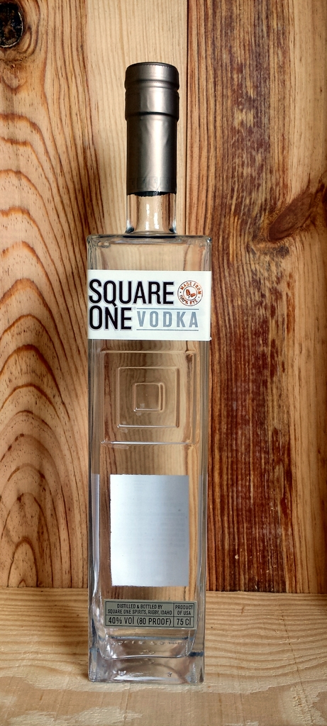 Eine Wodkaflasche wird vor einer hölzernen Wand platziert.