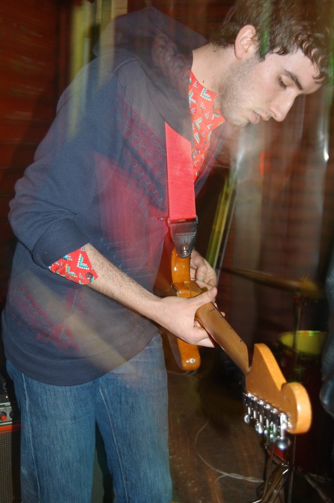 Ein Mann hält und spielt eine akustische Gitarre.