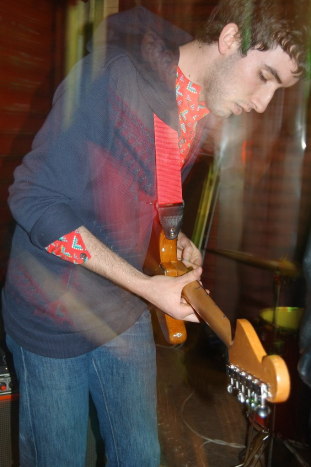 Ein Mann hält und spielt eine akustische Gitarre.