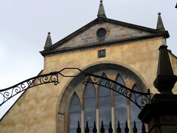 Ein Bogen in der Mitte des Bildes mit einem Gebäude im Hintergrund, das Glasfenster aufweist.