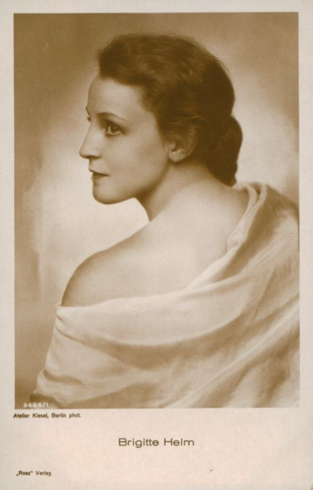 Schwarzes und weißes Foto von Brigitte Helm, einer deutschen Schauspielerin, in einem weißen Kleid mit Text unten.