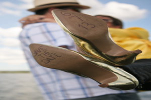 Frauen-High-Heels mit Datumsangaben, mit einer Person, die eine Frau an den Beinen hält.