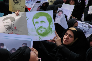 Eine Gruppe iranischer Frauen in schwarzer Kleidung, einige mit Brille, halten Fotos von Präsident Mahmoud Ahmadinejad während einer Demonstration in Teheran hoch.