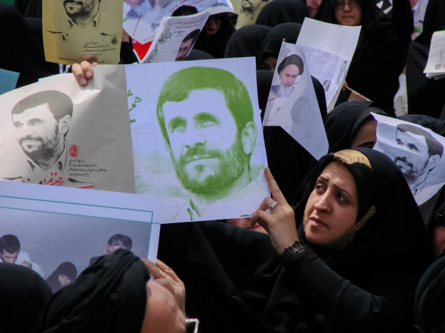 Eine Gruppe iranischer Frauen in schwarzer Kleidung, einige mit Brille, halten Fotos von Präsident Mahmoud Ahmadinejad während einer Demonstration in Teheran hoch.