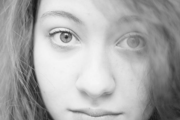 Eine Frau mit schwarzem Haar, zwei Augen, einer Nase und einem Mund.